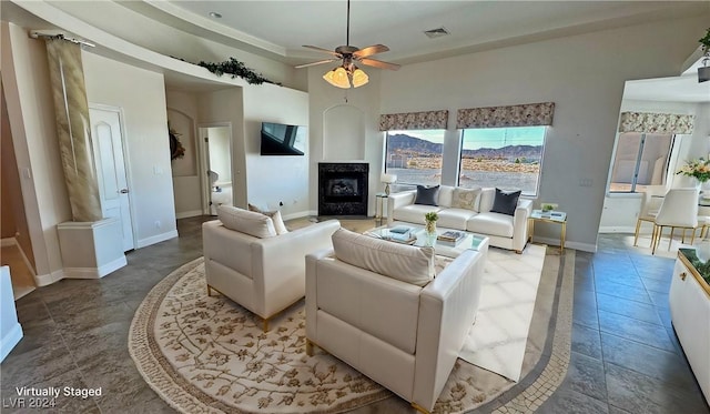 living room featuring tile patterned floors, ceiling fan, and a large fireplace