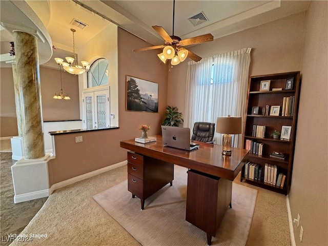 home office featuring decorative columns, light carpet, and ceiling fan with notable chandelier