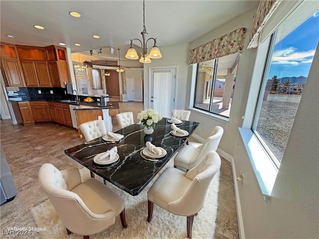 dining room with a wealth of natural light, sink, and an inviting chandelier