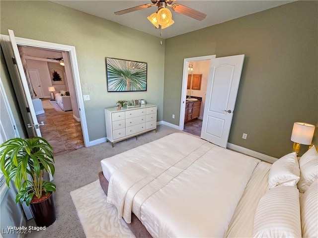 bedroom with ensuite bathroom, ceiling fan, and light colored carpet