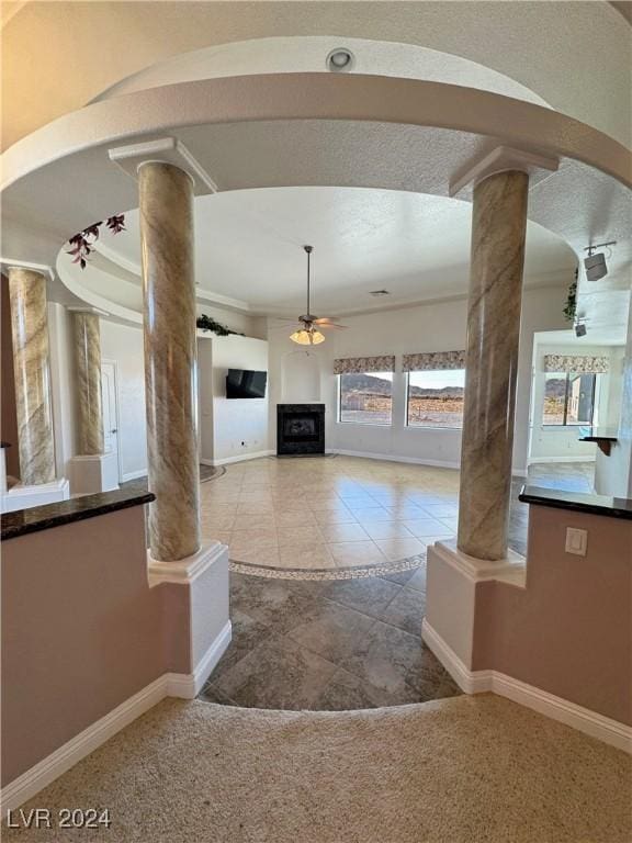 interior space featuring light tile patterned floors and ornate columns