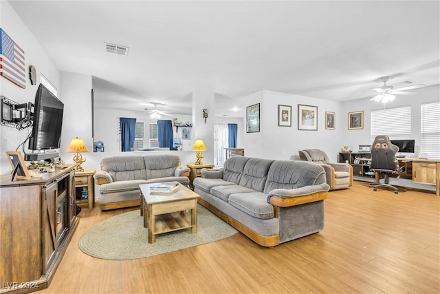 living room with a wealth of natural light, ceiling fan, and wood-type flooring