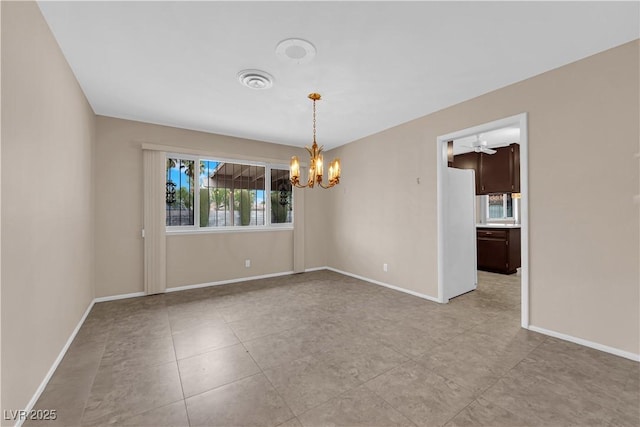 unfurnished room with an inviting chandelier, light tile patterned flooring, visible vents, and baseboards