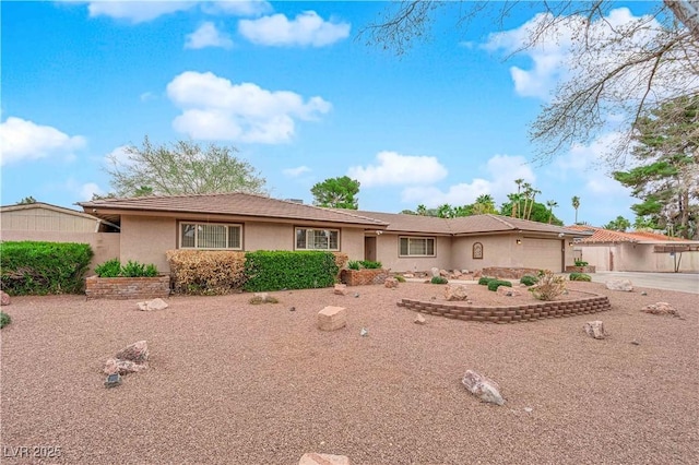 ranch-style home with stucco siding and a garage