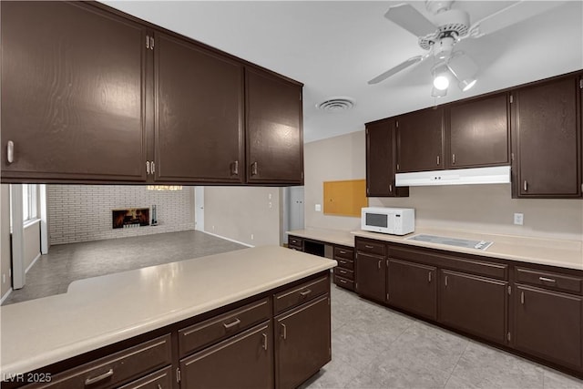 kitchen featuring a ceiling fan, white microwave, visible vents, electric stovetop, and under cabinet range hood