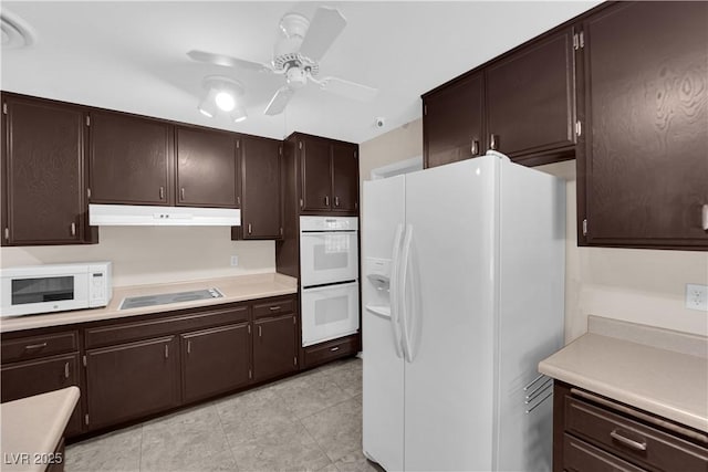 kitchen featuring under cabinet range hood, dark brown cabinetry, light countertops, white appliances, and a ceiling fan