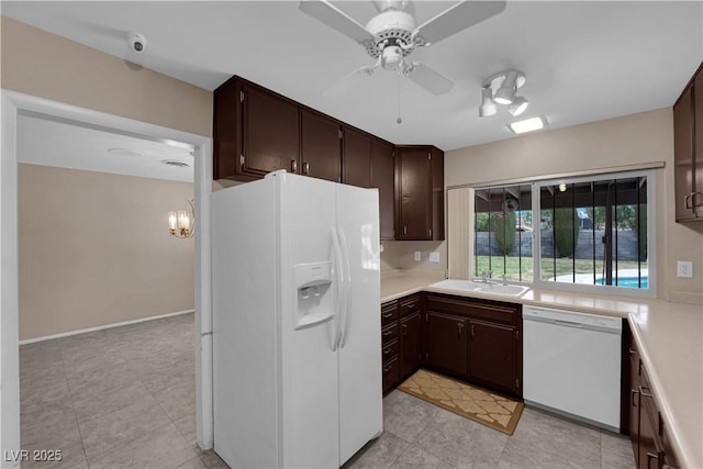 kitchen featuring dark brown cabinetry, white appliances, light countertops, and a ceiling fan