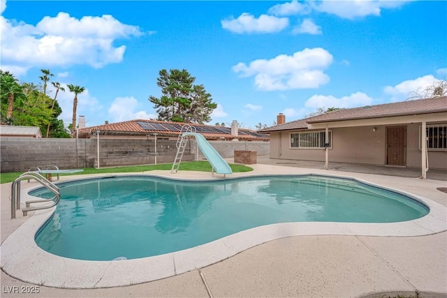 view of pool with a patio area, a fenced in pool, and a water slide