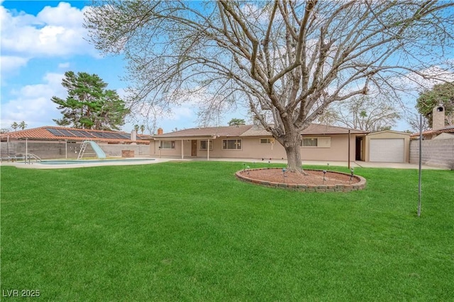 view of yard with a fenced in pool, a garage, and fence