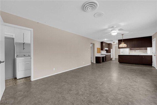 unfurnished living room with washer / dryer, visible vents, baseboards, and ceiling fan