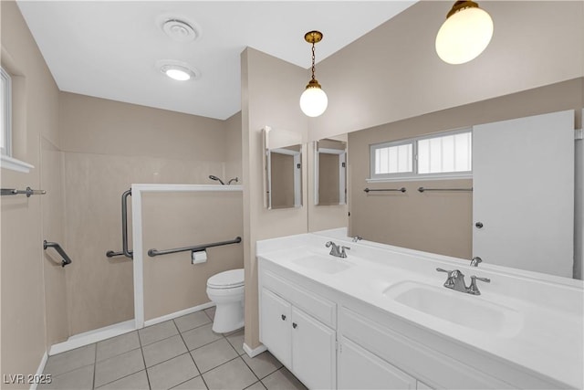 bathroom featuring tile patterned flooring, double vanity, toilet, and a sink