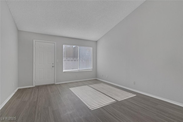 empty room with dark hardwood / wood-style floors and a textured ceiling