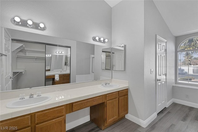 bathroom featuring vaulted ceiling, hardwood / wood-style floors, and vanity