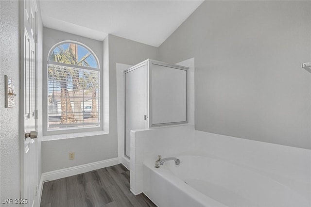 bathroom with hardwood / wood-style flooring, shower with separate bathtub, and lofted ceiling