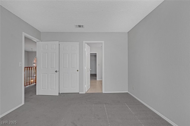 unfurnished bedroom with carpet, a textured ceiling, and a closet