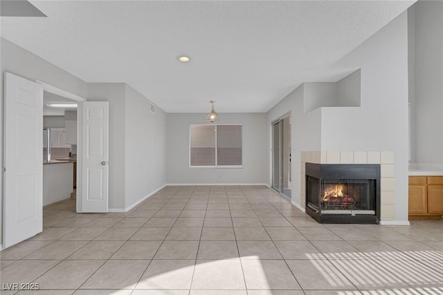 unfurnished living room featuring a fireplace and light tile patterned floors