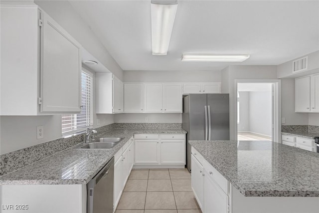 kitchen with white cabinetry, sink, stainless steel appliances, and a kitchen island