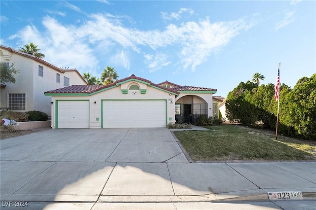 mediterranean / spanish-style home featuring a garage and a front lawn