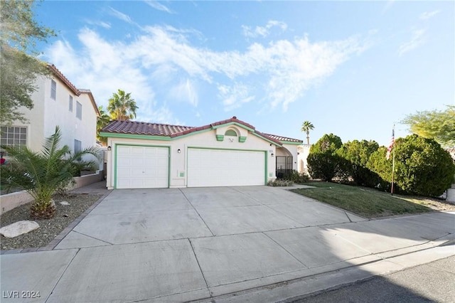 mediterranean / spanish house with a front lawn and a garage