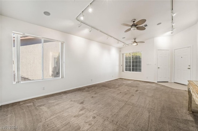 carpeted empty room featuring ceiling fan, lofted ceiling, and rail lighting