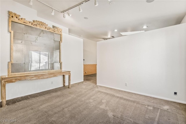 unfurnished room with carpet floors and rail lighting