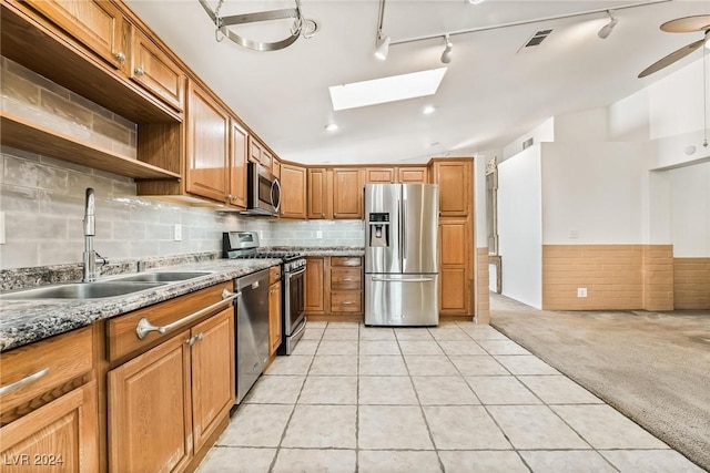 kitchen featuring ceiling fan, sink, stainless steel appliances, light stone counters, and light colored carpet