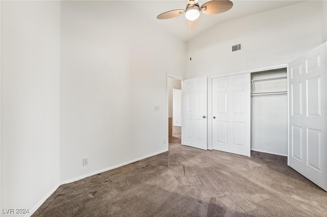 unfurnished bedroom with ceiling fan, a closet, carpet, and high vaulted ceiling