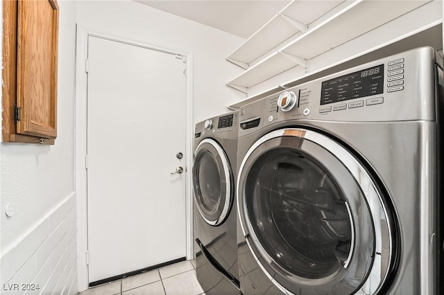 clothes washing area featuring washing machine and clothes dryer and light tile patterned floors