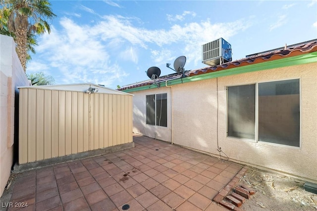 view of patio / terrace featuring central AC unit and a storage shed