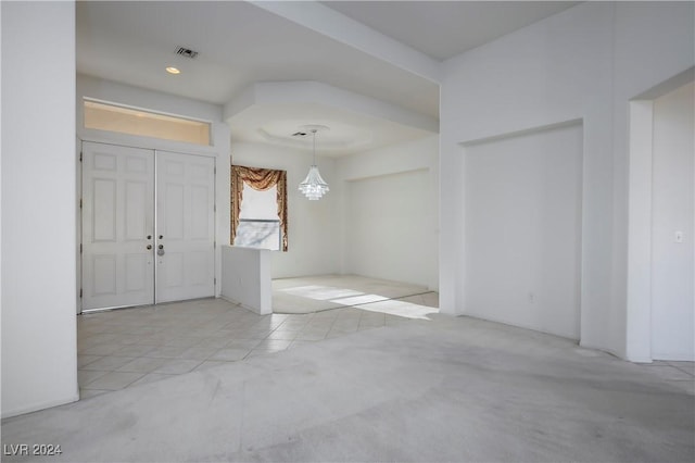 carpeted entryway featuring a notable chandelier