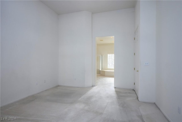 unfurnished room featuring light carpet