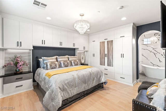 bedroom with light wood-type flooring and a chandelier