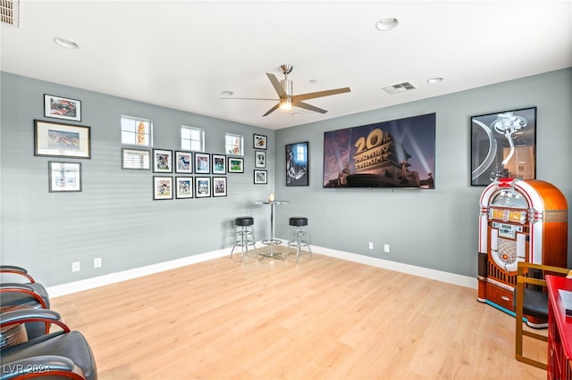 sitting room with ceiling fan and light wood-type flooring