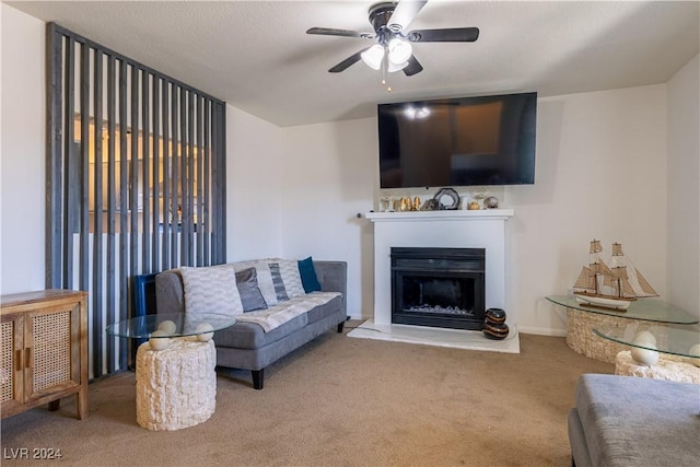 living room with carpet, ceiling fan, and a textured ceiling