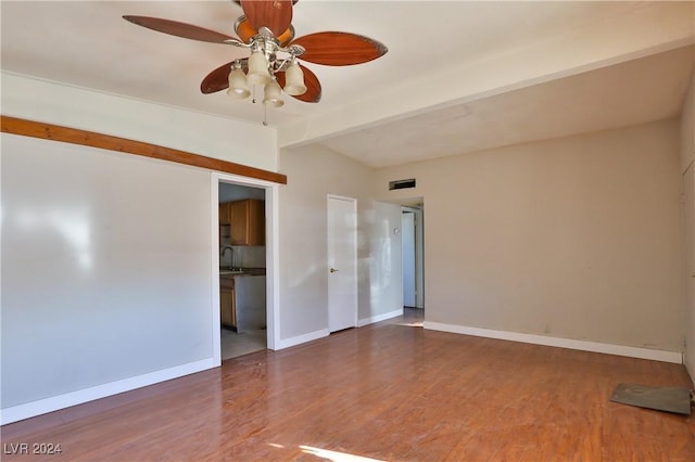 empty room with vaulted ceiling with beams, ceiling fan, dark hardwood / wood-style flooring, and sink