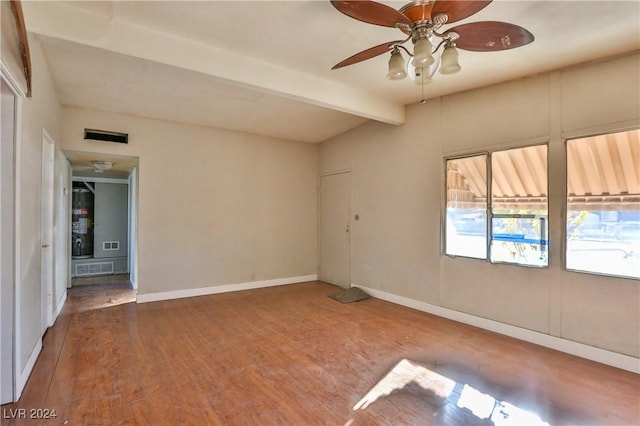 empty room with beam ceiling, ceiling fan, and hardwood / wood-style flooring