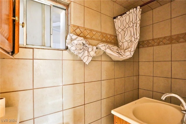 bathroom featuring sink and tile walls