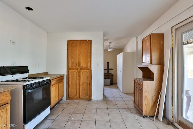 kitchen with white gas range, ceiling fan, and light tile patterned floors