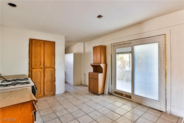 kitchen featuring light tile patterned floors and white gas range oven