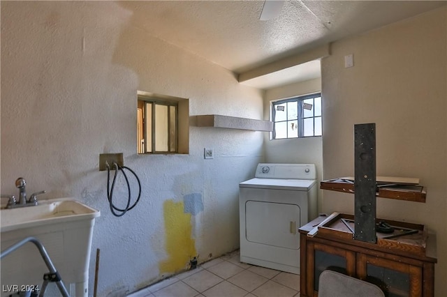 washroom with sink, light tile patterned floors, a textured ceiling, and washer / dryer