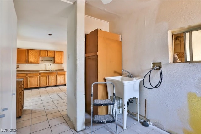 laundry room with light tile patterned floors, hookup for a washing machine, and sink