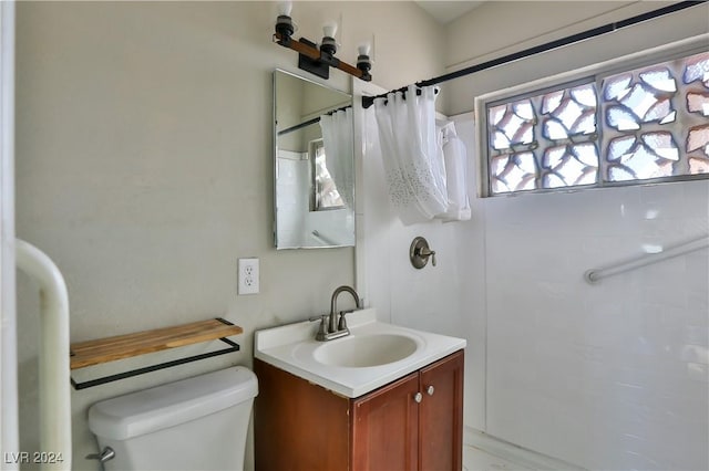 bathroom with toilet, vanity, and a shower with shower curtain