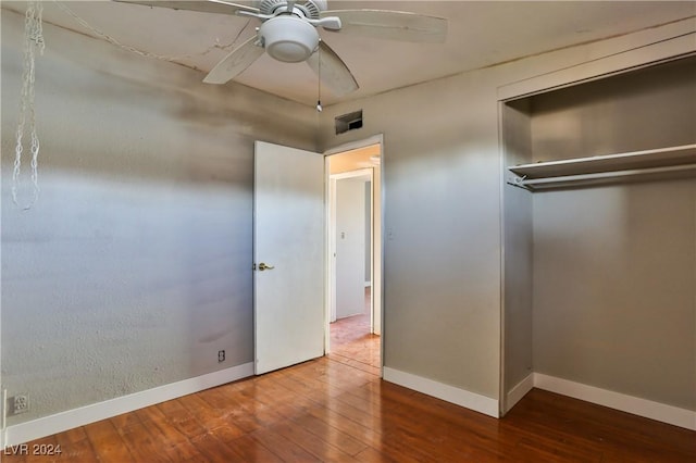 unfurnished bedroom with ceiling fan, a closet, and wood-type flooring