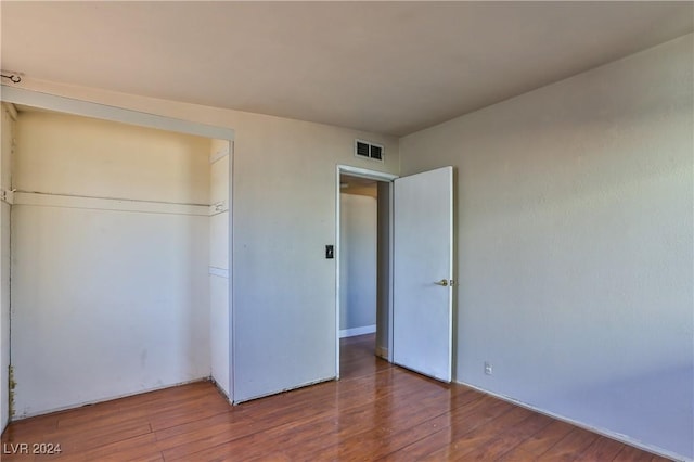 unfurnished bedroom featuring hardwood / wood-style flooring and a closet