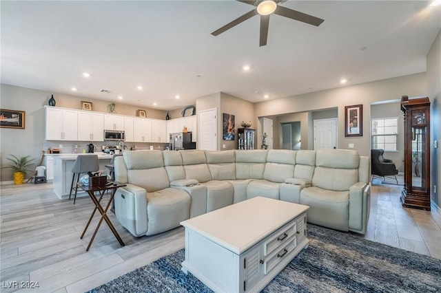 living room with ceiling fan and light hardwood / wood-style floors