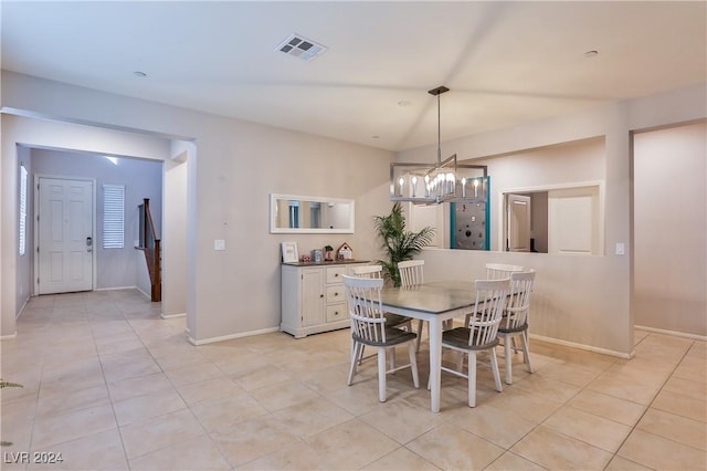 dining room featuring light tile patterned flooring and an inviting chandelier