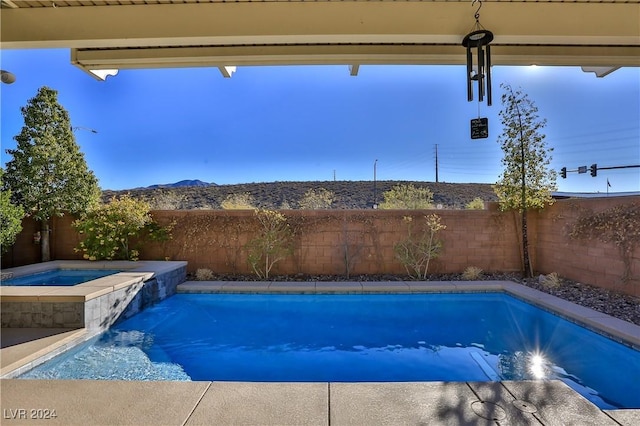 view of swimming pool with an in ground hot tub