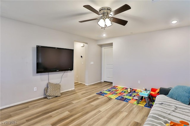 playroom with ceiling fan and light hardwood / wood-style flooring