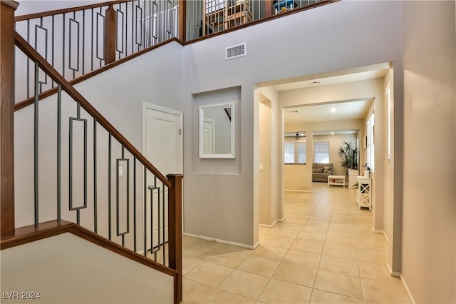 tiled entryway with a towering ceiling