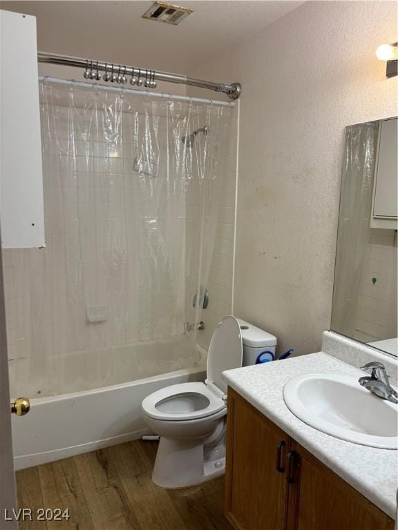 full bathroom featuring toilet, shower / bathtub combination with curtain, hardwood / wood-style floors, and vanity